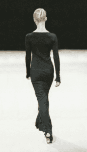 Vintage archival Azzedine Alaia Spring Summer 2003 Couture collection black asymmetric mermaid long maxi dress worn on the runway on a mannequin turning back with a black background