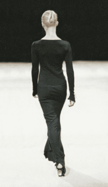 Vintage archival Azzedine Alaia Spring Summer 2003 Couture collection black asymmetric mermaid long maxi dress worn on the runway on a mannequin turning back with a black background