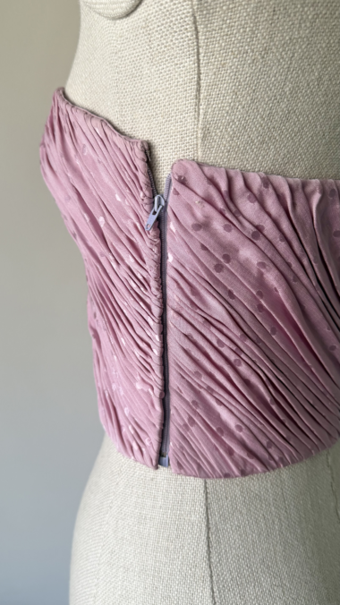 close-up of emanuel ungaro corset side zip closure on pink silk fabric